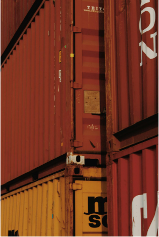 Stacked shipping containers in red and yellow, illustrating the context of container loading and unloading operations.