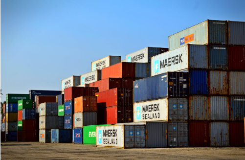 Colorful shipping containers stacked in a freight yard, showcasing various brands including Maersk, relevant to discussions on container ramps and warehouse efficiency.