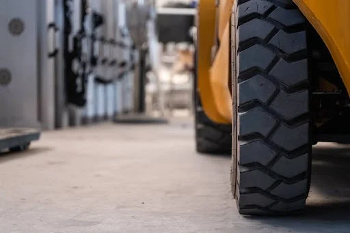 Close-up of a forklift tyre on a concrete floor, highlighting tread pattern and durability, relevant to discussions on forklift maintenance and tyre replacement.