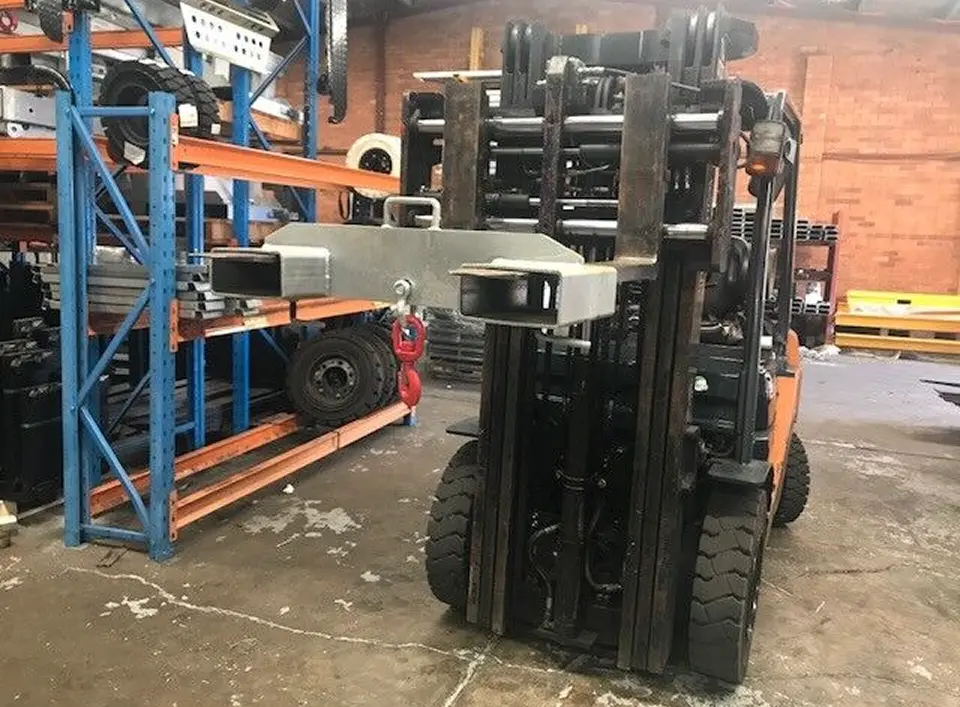 Forklift with attachment in warehouse setting, showcasing heavy-duty design and surrounding industrial equipment, emphasizing Mandarin Imports & Exports' focus on forklift parts and warehouse solutions.