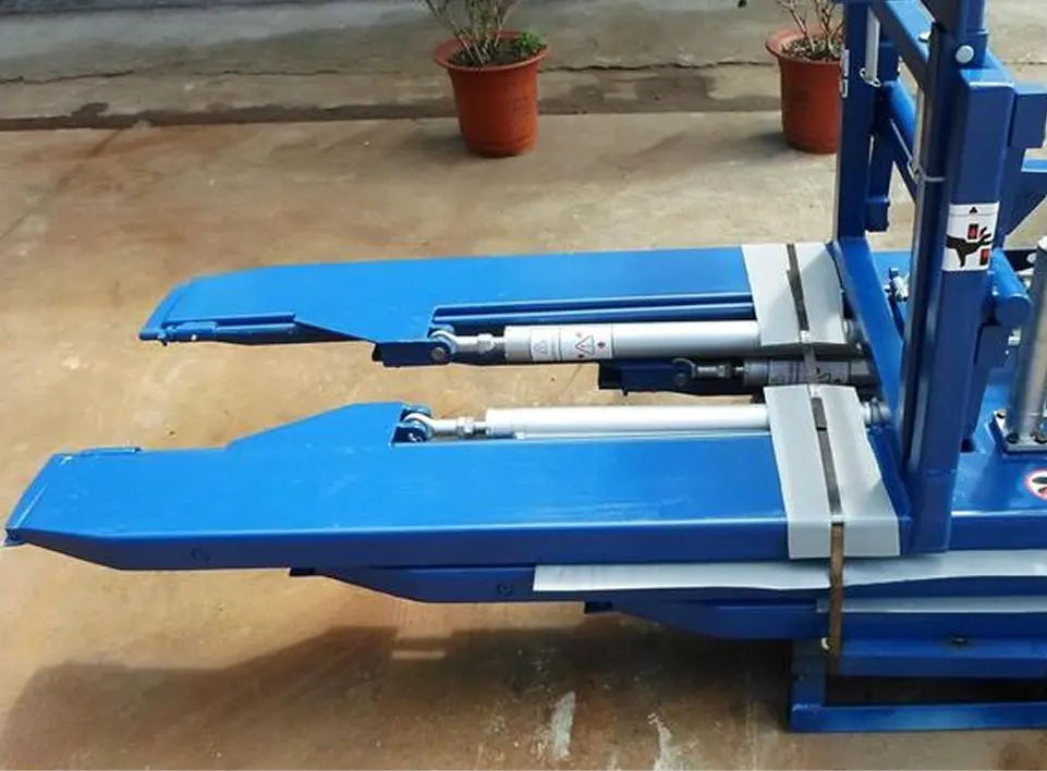 Forklift attachment with blue hydraulic forks designed for efficient material handling in warehouse operations.