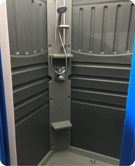 Portable stand-alone shower unit featuring hot and cold water controls, wall-mounted showerhead, and built-in seating, designed for construction sites and outdoor work areas.