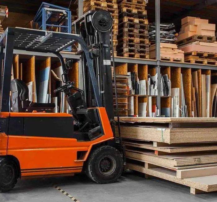 Forklift in warehouse setting, surrounded by stacked pallets and various materials, representing Mandarin Imports & Exports' focus on high-quality warehouse solutions and equipment.