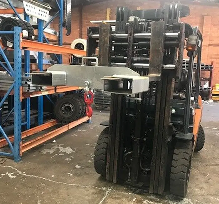 Forklift with reconditioned attachment in warehouse setting, showcasing Mandarin Imports & Exports' equipment solutions and support for industrial operations.