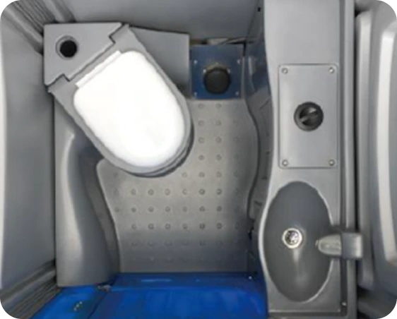 Portable toilet interior featuring a ceramic flushable toilet, hand washing basin with tap, and waste tank access, designed for outdoor hygiene solutions in construction settings.