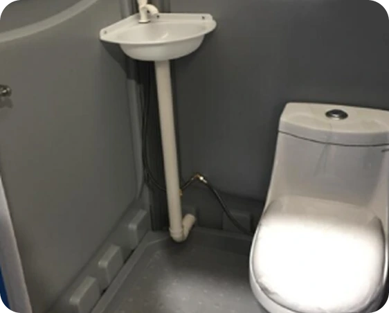Portable toilet interior featuring a ceramic flushable toilet and a plastic hand washing basin, designed for hygiene and convenience in high-traffic environments.